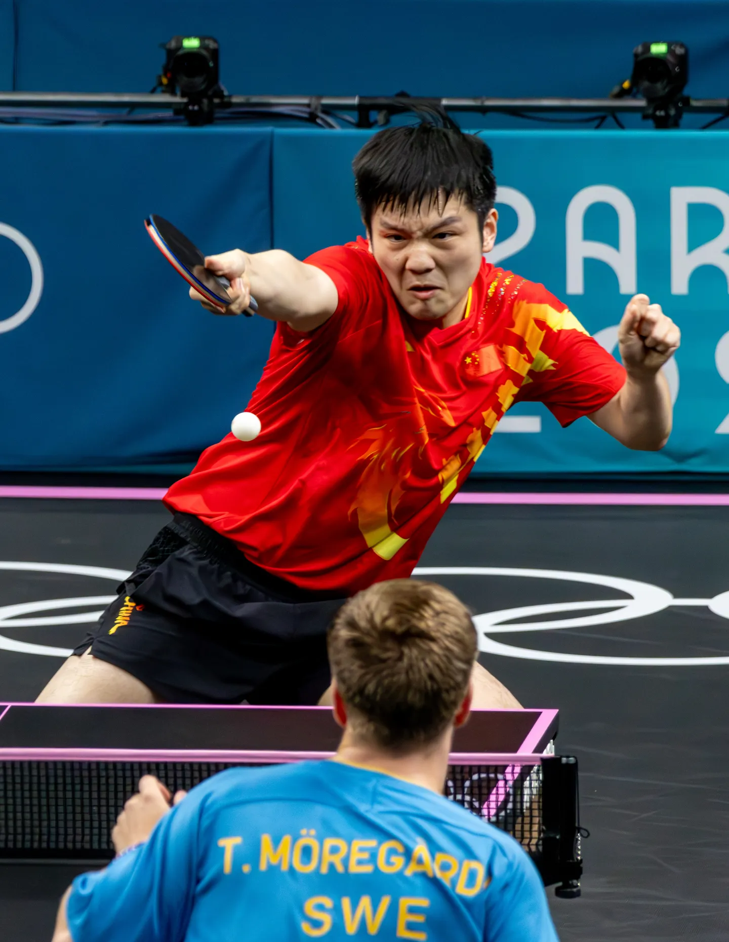 Fan Zhendong driving a backhand across the table at Truls Möregård during the men's singles final.