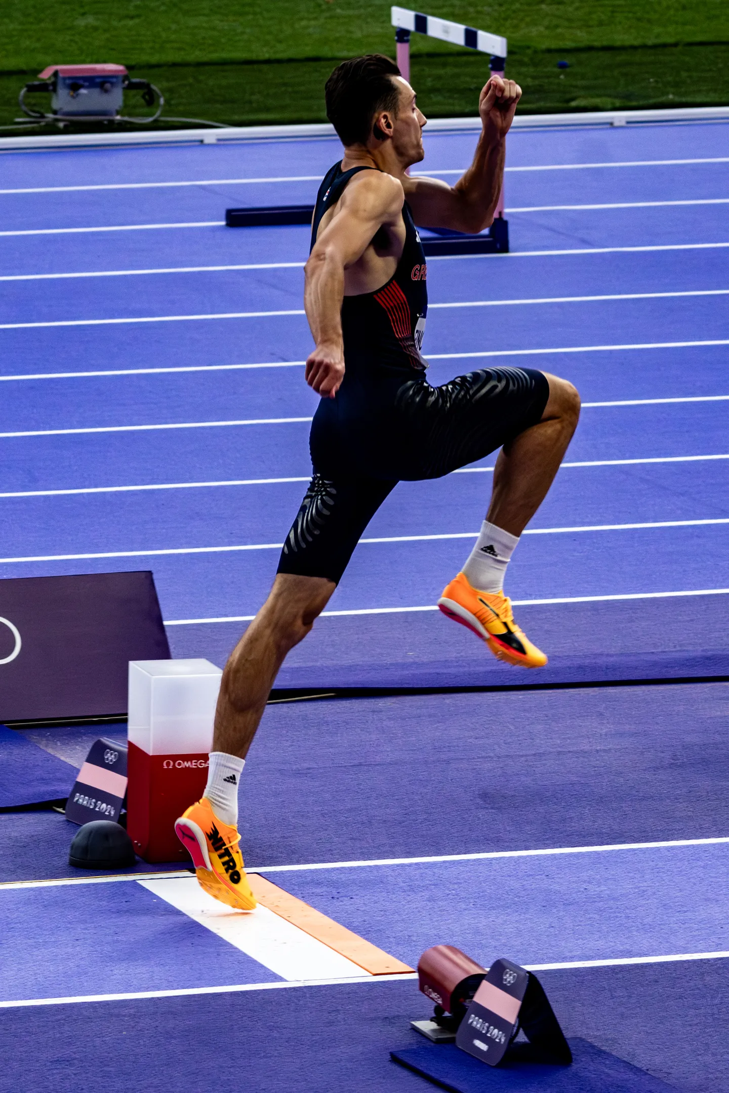 Long jumper off the takeoff board on the violet track at the Stade de France.