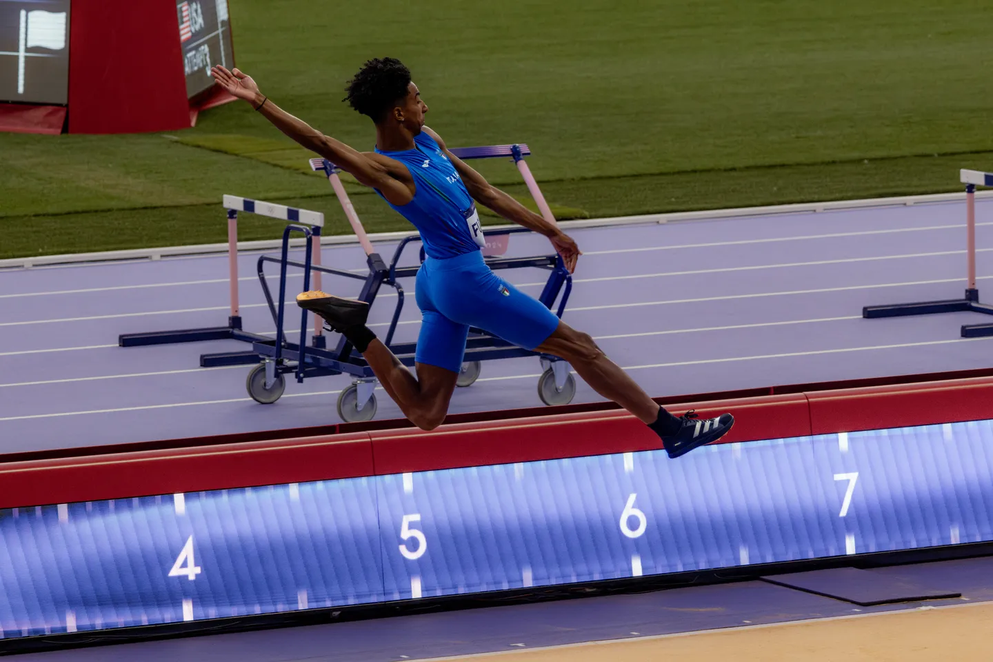 Long jumper extending over the pit.